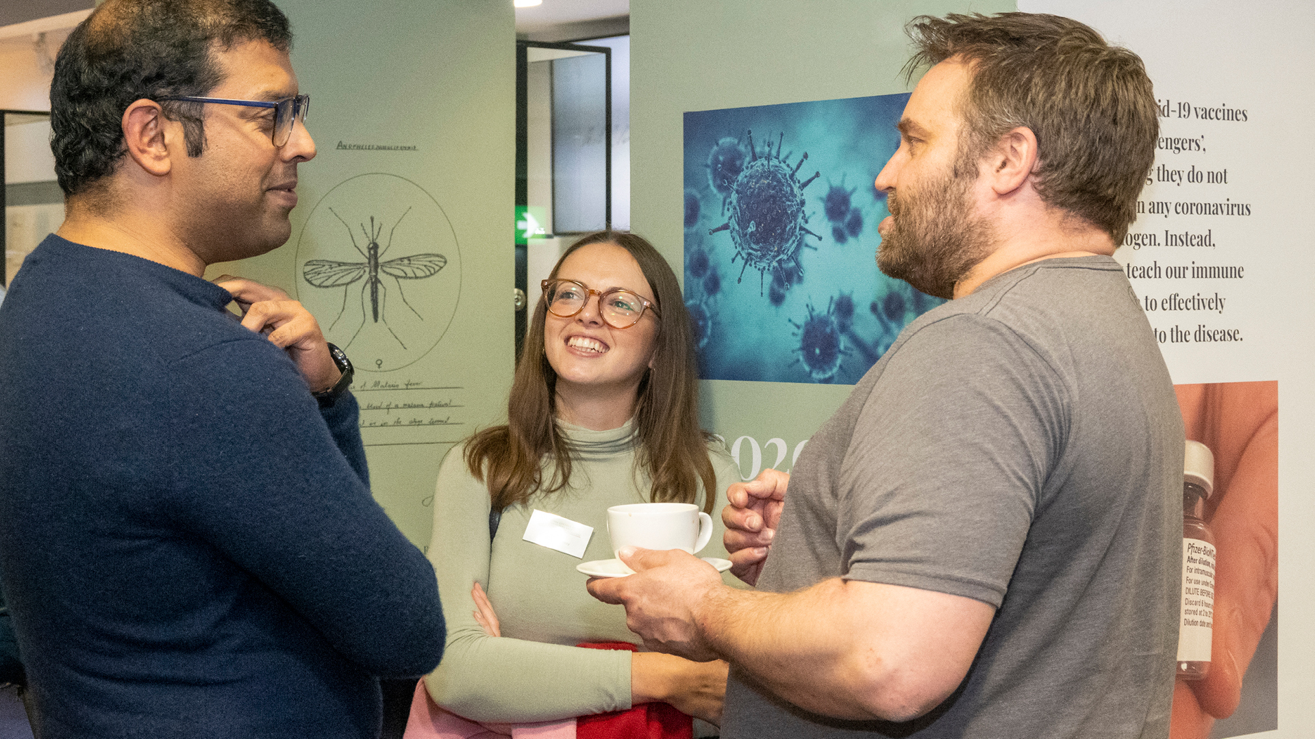 Three clinicians in discussion during coffee break in Crush Hall exhibition area